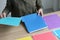 Secretary sorts colorful folders with materials on table