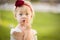 Secretive Little Girl Wearing White Dress In A Grass Field