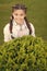 Secrets to raising happy child. Girl cute kid green grass background. Healthy emotional happy kid relaxing outdoors