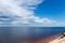 Section of big reservoir with sandy shore fragment against sky