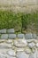 Section of a decorative weathered old wall by the sea in Normandy, stone in part concrete, with algae and moss, copy space, space