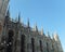 Section of the Duomo di Milano: slim spires standing tall above the magnificent Gothic cathedral with its white stone walls