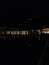 Section of nighttime panorama of Como, Italy. Lights of the town in black night, reflected in the water of the Como lake