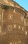 Section of an old historical brick wall in Rome, with sunrays reflected from the building opposite creating ornamental patterns