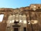 Section of an old historical brick wall in Rome with a white-stone portal, with reflected sunrays creating interesting ornaments