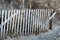 Section of old rusting wood fencing at sandy beach