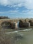 Section of Roman Bridge in Cordoba across Guadalquivir river on a bright sunny day against blue sky with small figures of people