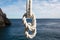 secure bowline knot on a white rope with ocean backdrop