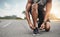 Secure yourself first. Closeup shot of a sporty man tying his shoelaces while exercising outdoors.