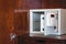Security open metal safe with empty space inside in a wooden shelf. White safe box open door. Safe box with electronic lock in the