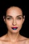 Seductive fashionable woman with blue and red lips looking at camera