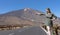 Seductive white caucasian tourist woman, hitch hiker in the volcano of el Teide, Tenerife, with a green dress. Excited independent