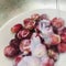 Seedless red grapes being washed in the sink in the white bowl. Square photo image.