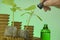 Seedling root system activator in a green glass bottle, a cucumber plant and a pipette in a hand on a green background