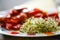 Seeds sprouted in a glass jar in a plate with red tomatoes