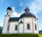 Seekirchl Heilig Kreuz urrounded by greenery under a blue sky in Seefeld, Austria