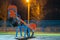 Seesaw swing in preschool yard with soft rubber flooring at night