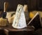 Segment of blue cheese or Cambozola cheese on wooden board. Different cheeses at the background