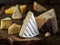 Segment of  Brie cheese or soft cow`s - milk  French cheese on wooden board. Different cheeses at the background