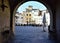 A segment, seen through a vaulted entrance, of the amphitheater square in Lucca.