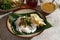 Sego Pecel Tumpang, Traditional Breakfast with Rice Nasi Topping with Tempeh and Boiled Vegetable, Served with Peyek Crackers.