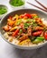 Seitan stripes in spicy chili ginger sauce with vegetables stir-fry and rice in a bowl. Delicious vegan dish. Healthy diet