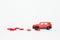 Selecitive focus miniature red car with present heart box on roof with red heart on white background, copy space. Idea surprise