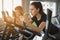 Select focus on Attractive Caucasian woman cycling on bike machine in gym fitness sport complex