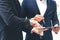 Selected focus on businessman hand pointing on the document, letting the partner sign on the paper for business agreement or