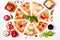 Selection of Assorted pieces pizza on white background and ingredients. Pepperoni, Vegetarian and Seafood Pizza