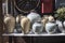 Selection of clay amphorae and pots of various shapes and colors on a shelf against the background of decorative mailboxes