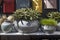 Selection of clay amphorae and pots of various shapes and colors on a shelf against the background of decorative mailboxes