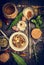 Selection of colorful herbs and spices in spoon and bowl on rustic wooden background