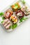 Selection of Danish smorrebrod open sandwiches on a platter on white background. Portrait orientation