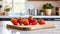 A selection of fresh fruit: strawberries, sitting on a chopping board against blurred kitchen background copy space