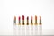 selection of highend lipsticks in a row against white