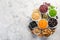 Selection of legumes in white bowls on stone background