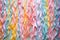 a selection of paper streamers in rainbow colors laid out on a pastel surface