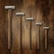 A selection of precision carpentry hammers on a wooden backdrop