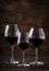 Selection of red wine on wine tasting. Dry, semi-dry, sweet red wines in special wine glasses on old wooden table background. Copy