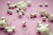 Selection of scattered silver beads on pink background