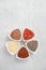 Selection of superfoods in white bowls on gray concrete background. Quinoa, chia, goji berry and flax seeds.