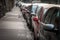 Selectiv view on the rearview mirrors of unrecognizable cars of various colors parked in parallel park in a European urban city