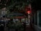 Selective blur on a bar patio and terrace with a neon light sign at night, in summer, with people enjoying their drinks outdoor