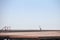 Selective blur on a grey heron, also called Ardea cinerea, seen from afar standing on a pier in Palic lake, in Serbia.