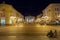 Selective blur people standing on the deserted Klauzal ter square near Kossuth Lajos Statue in the city center of Szeged at night