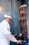 Selective blur on a Turkish man, kebab master chef cutting a skewer of meat for a Doner kebab sandwich in Istanbul, Turkey