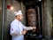 Selective blur on a Turkish man, kebab master chef sharpening his blade before cutting a skewer of meat for a Doner kebab sandwich