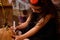 Selective focus on an adorable little girl looking like an enchantress, drawing a Halloween Jack on an orange pumpkin