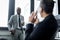 selective focus of african american businessan looking at colleague talking on smartphone